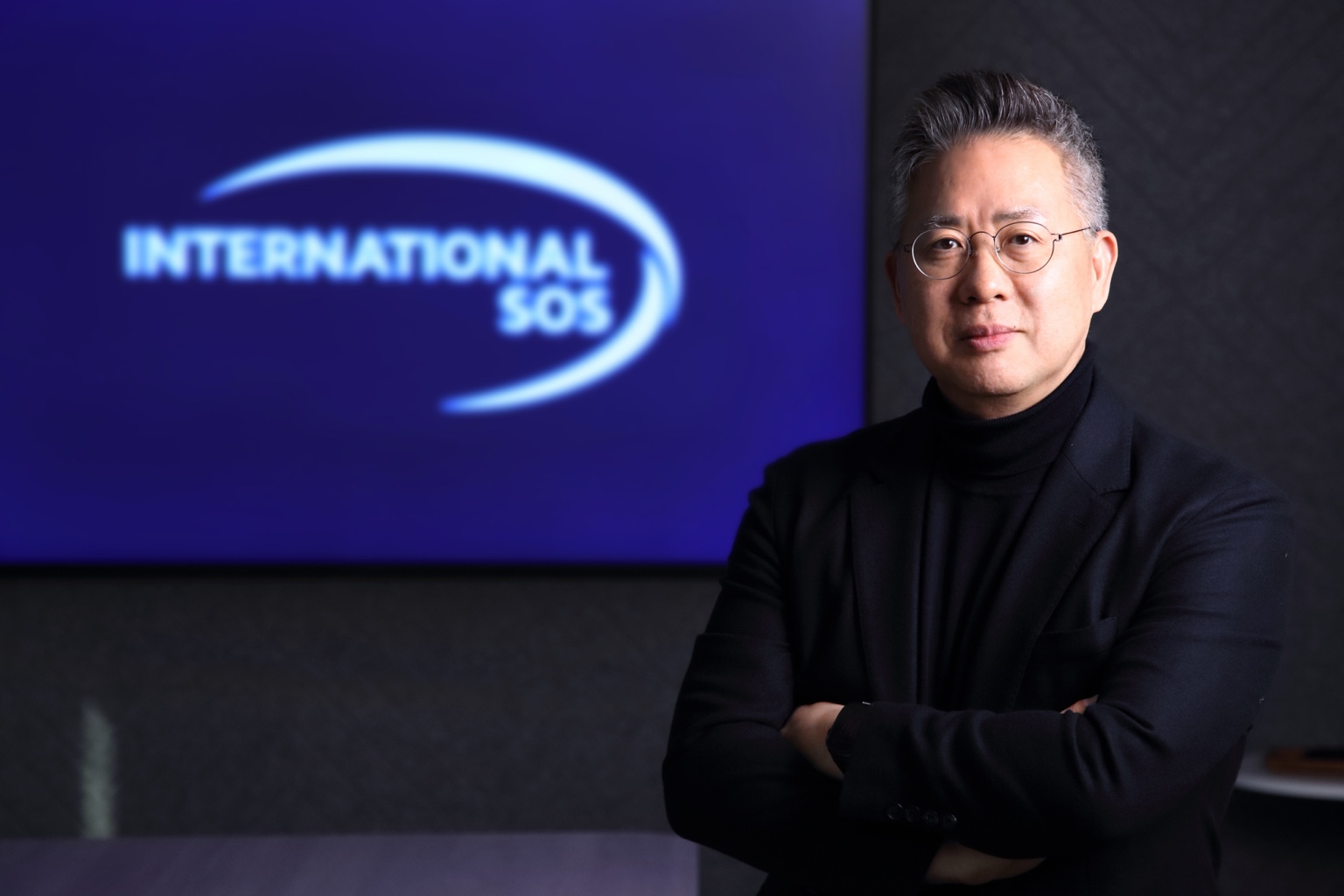 International SOS 로고 앞에 선 강승구